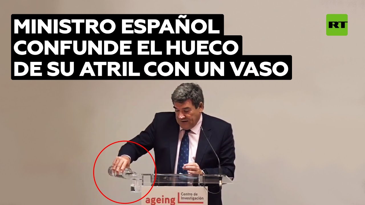Un ministro de España confunde el hueco de su atril con un vaso
