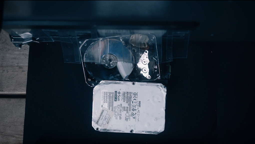 Observe cómo una máquina de reciclaje destroza discos duros viejos para recuperar componentes