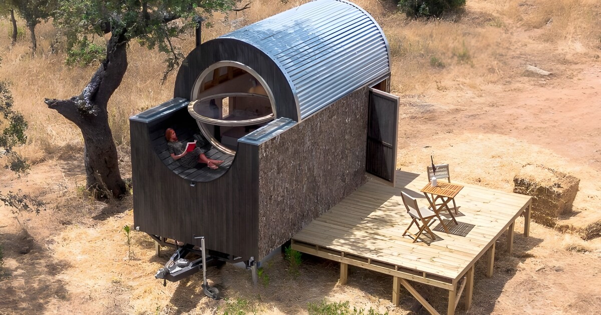 Pequeña casa de madera con interior compacto y un llamativo techo curvo