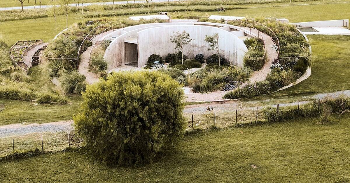 Una casa de hormigón autosuficiente desaparece en un paisaje exuberante