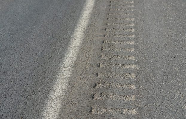 ¿Cuál es el propósito de las ranuras grabadas en el costado de la carretera?